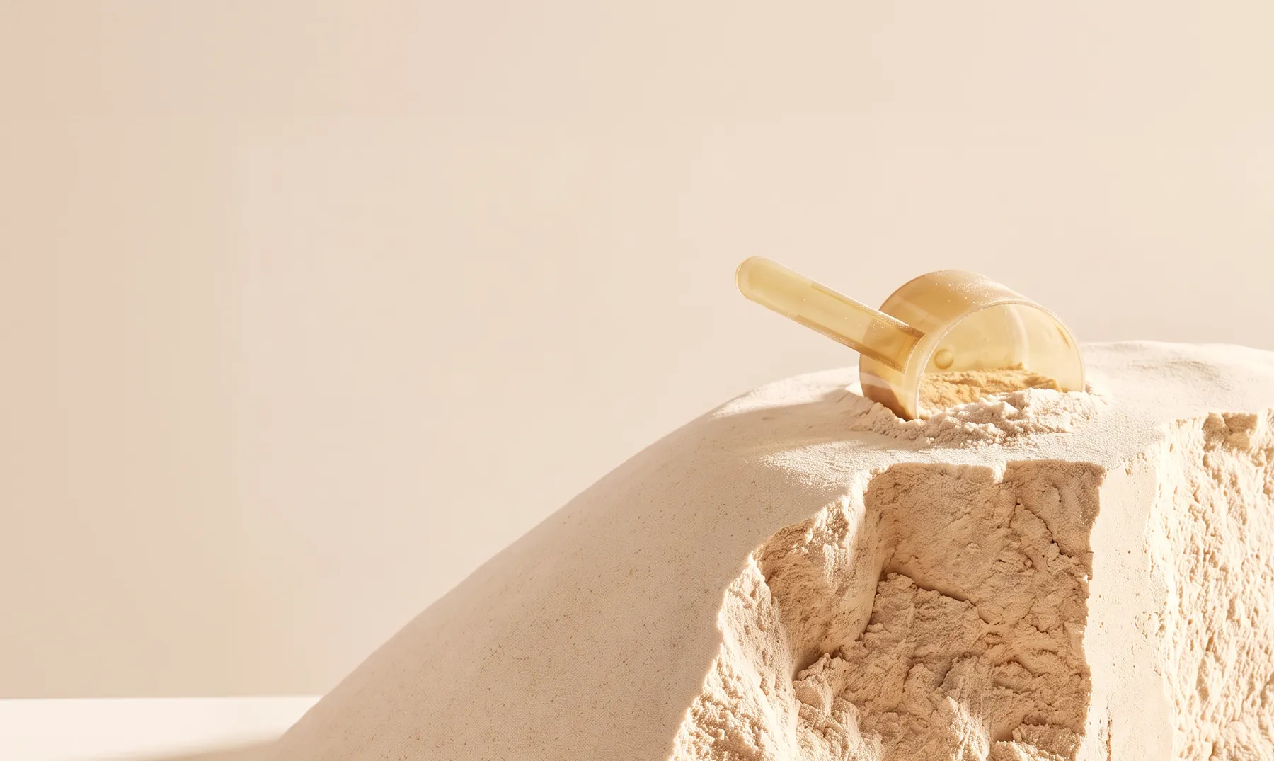 A mound of blended protein powder with a scoop resting on top